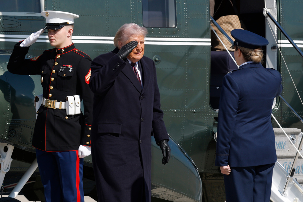 President Donald Trump, center, is greeted by Air Force 89th Air Wing Deputy Commander Melissa Dombrock, right, as he exits Marine One before boarding Air Force One, Friday, Feb. 27, 2025, at Joint Base Andrews, Md. (AP Photo/Luis M. Alvarez)