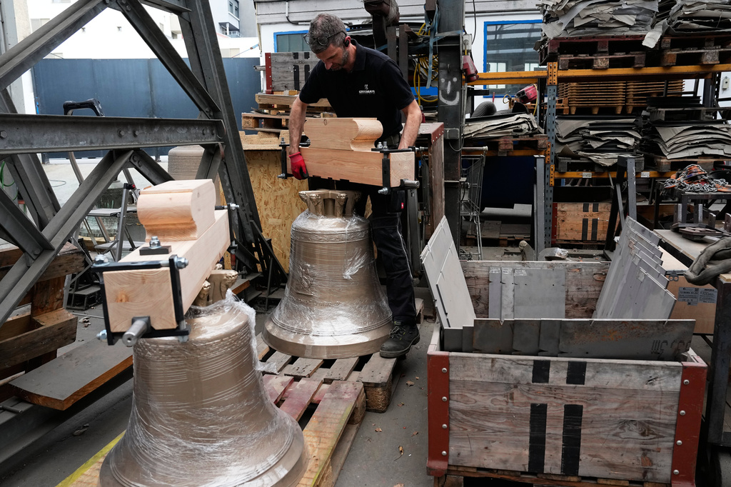 Mathias Rentzsch secures a bracket on a bell at the 400-year-old family-owned bell foundry Grassmayr in Innsbruck, Austria, Friday, July 17, 2026. (AP Photo/Matthias Schrader)