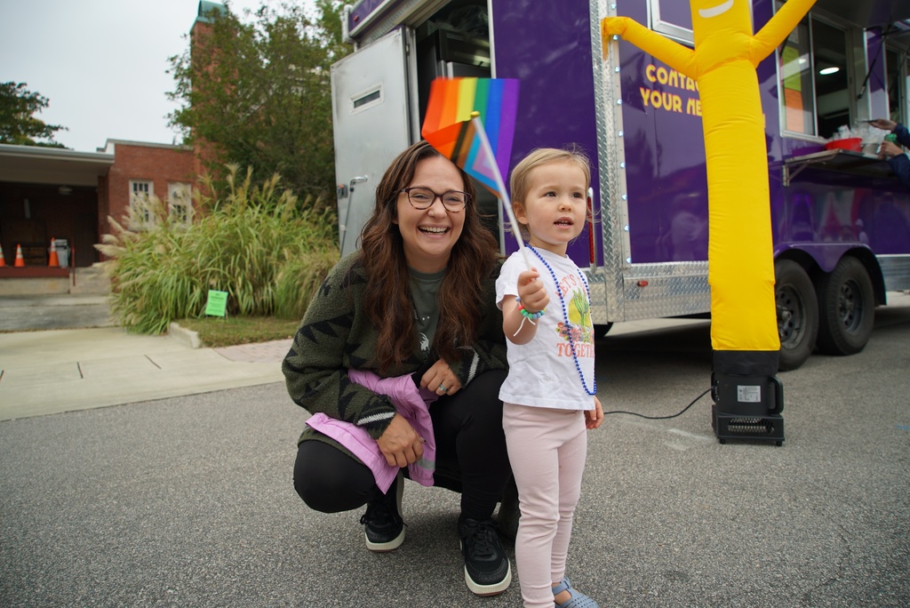 Nikki Lyons, left, laughs as her daughter, Maeve, 2, waves a flag at Pride Fest in Wake Forest, N.C., on Saturday, Oct. 11, 2025. (AP Photo/Allen G. Breed)