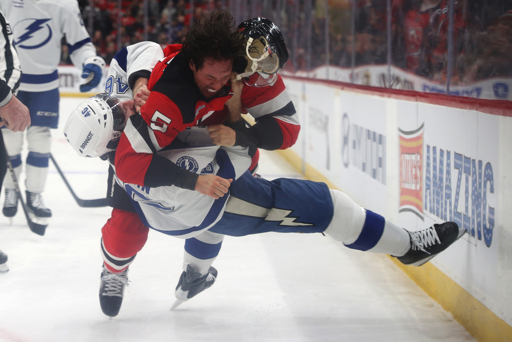 New Jersey Devils' Brenden Dillon (5) fights with Tampa Bay Lightning's Scott Sabourin (46) during the first period of an NHL hockey game Thursday, Dec. 11, 2025, in Newark, N.J. (AP Photo/Pamela Smith)