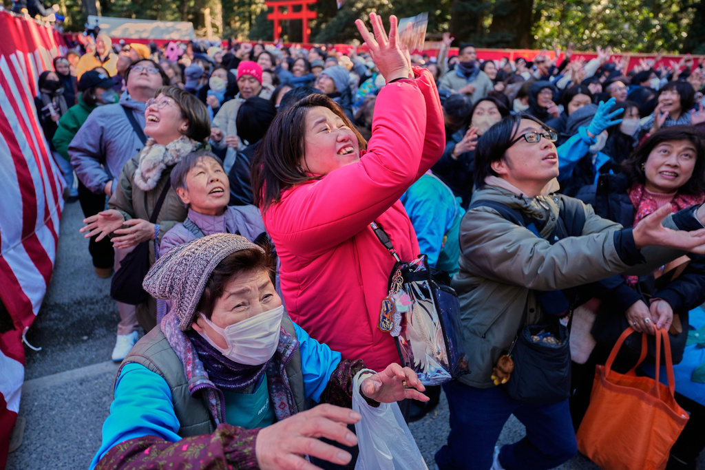 People try to catch lucky beans during the annual Bean Throwing Festival at Hakone Shrine in Hakone, Japan, Tuesday, Feb. 3, 2026. (AP Photo/Eugene Hoshiko)