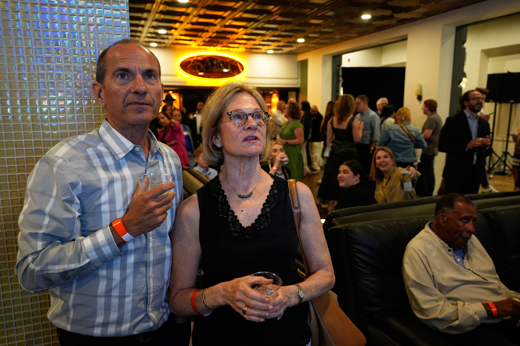 Attendees watch a TV as election results roll in during a primary election night event for Rep. Haley Stevens, D-Mich., a candidate in the Democratic primary for U.S. Senate in Michigan, Tuesday, Aug. 4, 2026, in Detroit. (AP Photo/Paul Sancya)