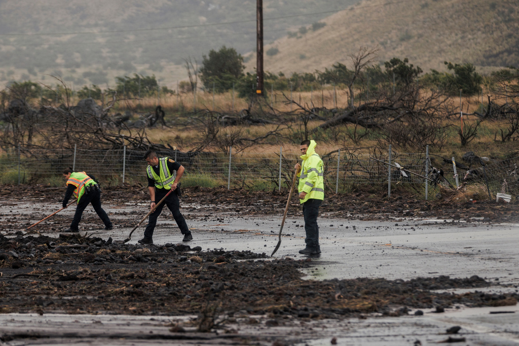 Police remove debris strewn across Daniel K. Inouye Highway by Hurricane Lala near Waimea, Hawaii, Sunday, Aug. 16, 2026. (Stephen Lam/San Francisco Chronicle via AP)