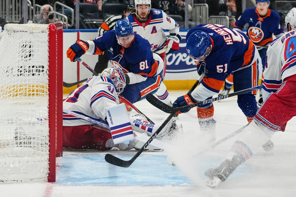 New York Rangers goaltender Spencer Martin (41)protects the net from New York Islanders' Emil Heineman (51) and Ondrej Palat (81) during the second period of an NHL hockey game Wednesday, Jan. 28, 2026, in Elmont, N.Y. (AP Photo/Frank Franklin II)