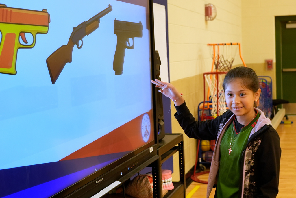 Jailyn Martinez points to a real firearm during a gun safety lesson at Berclair Elementary School, Monday, Oct. 27, 2025, in Memphis, Tenn. (AP Photo/George Walker IV)