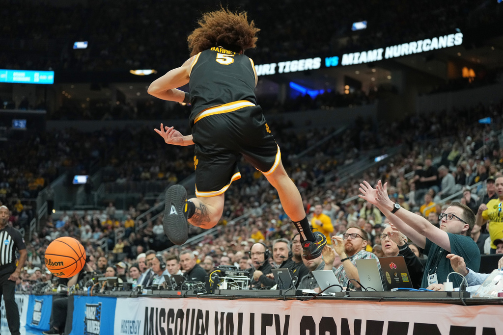 Missouri's T.O. Barrett on a court-side table as he tries to keep a ball in bounds during the first half in the first round of the NCAA college basketball tournament against Missouri, Friday, March 20, 2026, in St. Louis. (AP Photo/Jeff Roberson)