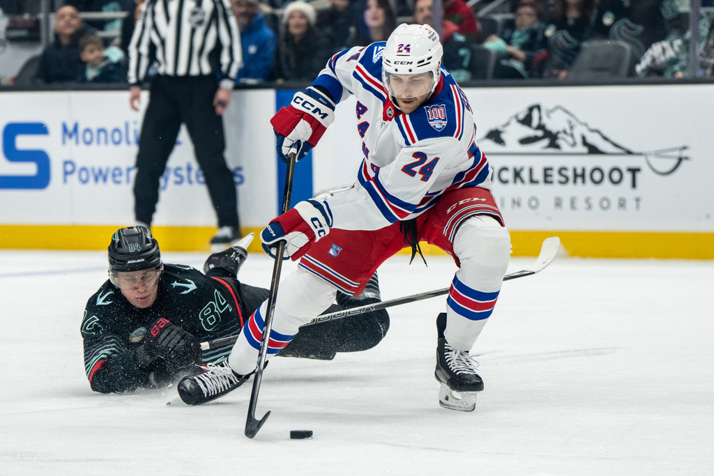 New York Rangers defenseman Carson Soucy (24) skates against Seattle Kraken forward Kaapo Kakko during the first period of an NHL hockey game, Saturday, Nov. 1, 2025, in Seattle. (AP Photo/Stephen Brashear)