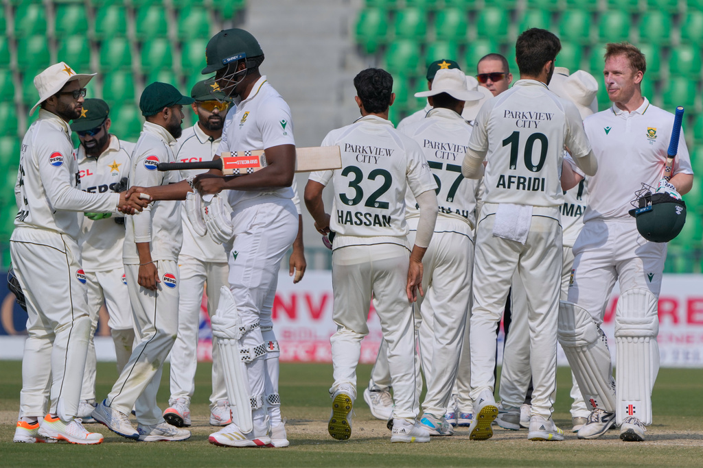 South Africa's Simon Harmer, right, and South Africa's Kagiso Rabada, fifth left, shakes hand with Pakistani players on the end of first test cricket match between Pakistan and South Africa, in Lahore, Pakistan, Wednesday, Oct. 15, 2025. (AP Photo/K.M. Chaudary)