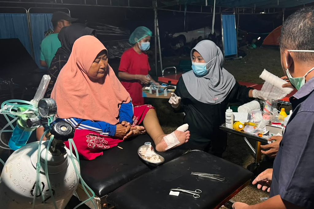 An erthquake survivor receives medical treatment at a makeshift medical center in Reo, East Nusa Tenggara province, Indonesia, Monday, Aug. 17, 2026. (AP Photo/Dicky Bisinglasi)
