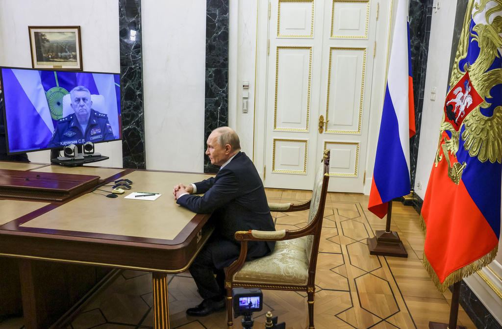 Russian Strategic Missile Forces chief, Col. Gen. Sergei Karakayev, left on the screen, reports to President Vladimir Putin on a successful test launch of the Sarmat intercontinental ballistic missile at the Kremlin in Moscow, Tuesday, May 12, 2026. (Mikhail Metzel/Sputnik, Kremlin Pool Photo via AP)