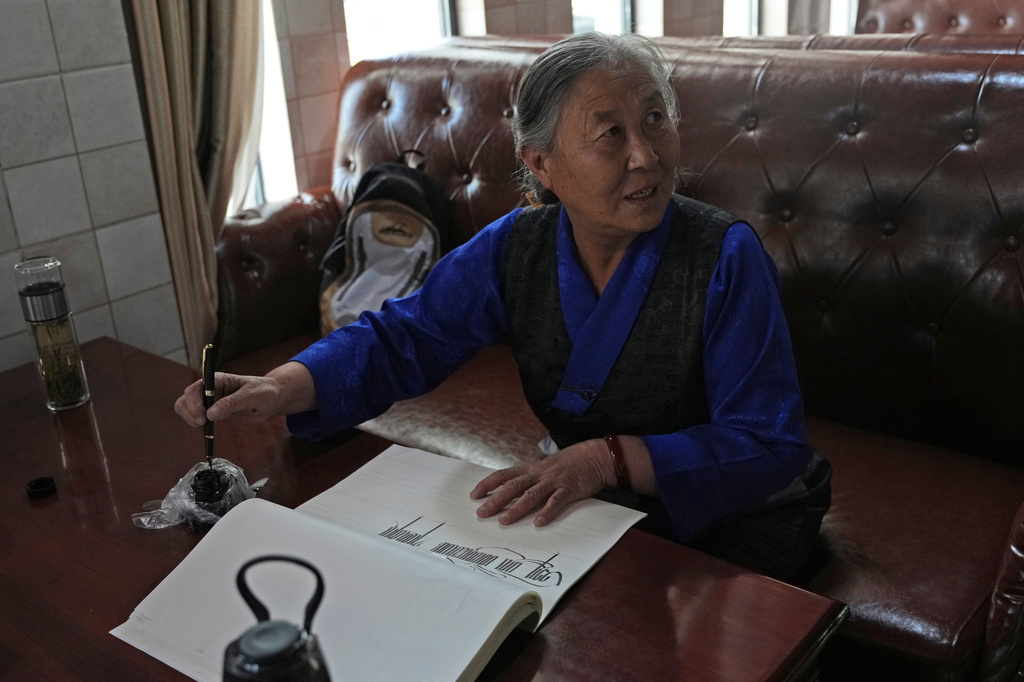 Kalsang Lhamo, a 73-year-old retired nurse, practices Tibetan calligraphy at the Chengguan District Day Care Center for the Elderly in western China's Tibet autonomous region on July 20, 2026, during a government-organized visit for foreign journalists.(AP Photo/Ng Han Guan)
