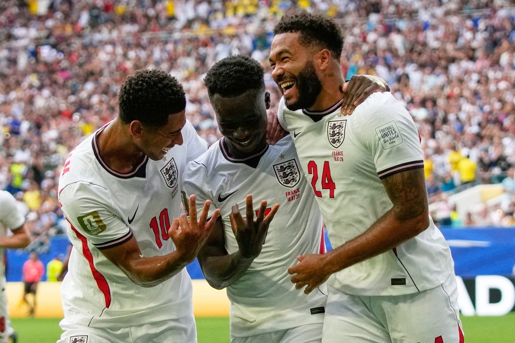 England's Bukayo Saka (7) is congratulated by Jude Bellingham (10) and Reece James (24) after scoring his side's 5th goal from the penalty spot during the World Cup third-place playoff soccer match between France and England in Miami Gardens, Fla., Saturday, July 18, 2026. (AP Photo/Lynne Sladky)