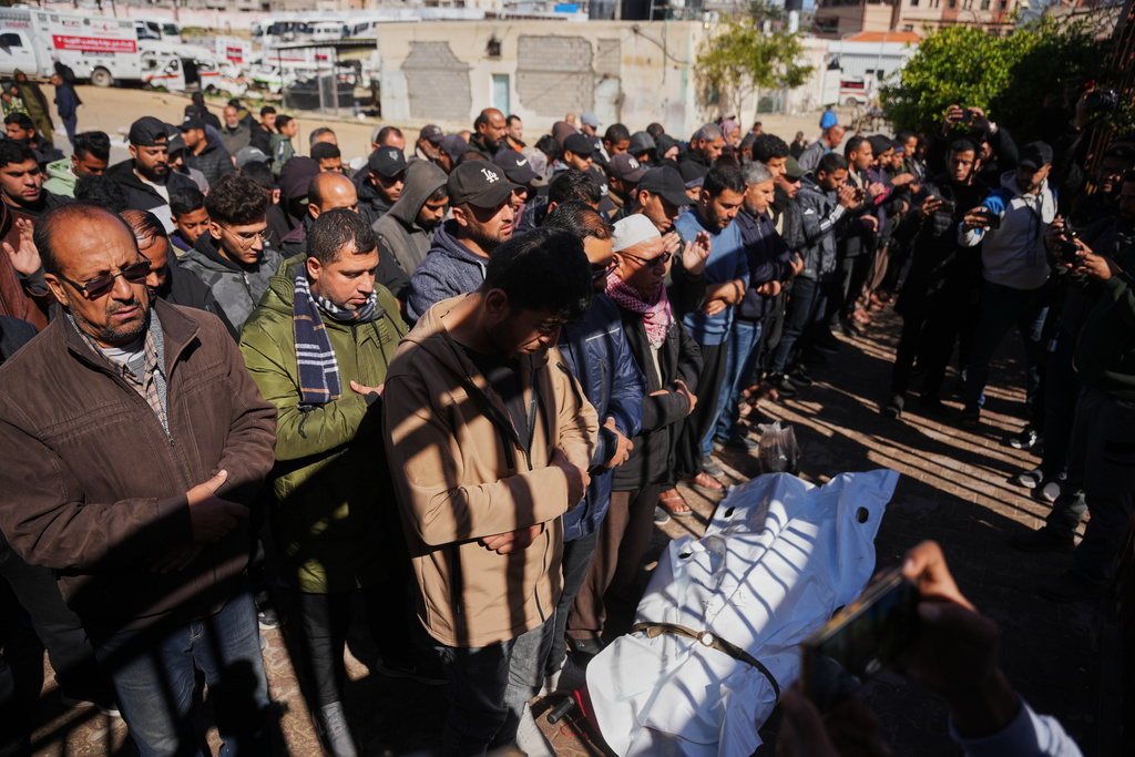 Mourners pray over the body of a Palestinian policeman who was killed in an Israeli military strike, at Nasser Hospital, in Khan Younis, southern Gaza Strip, Friday, Feb. 27, 2026. (AP Photo/Abdel Kareem Hana)