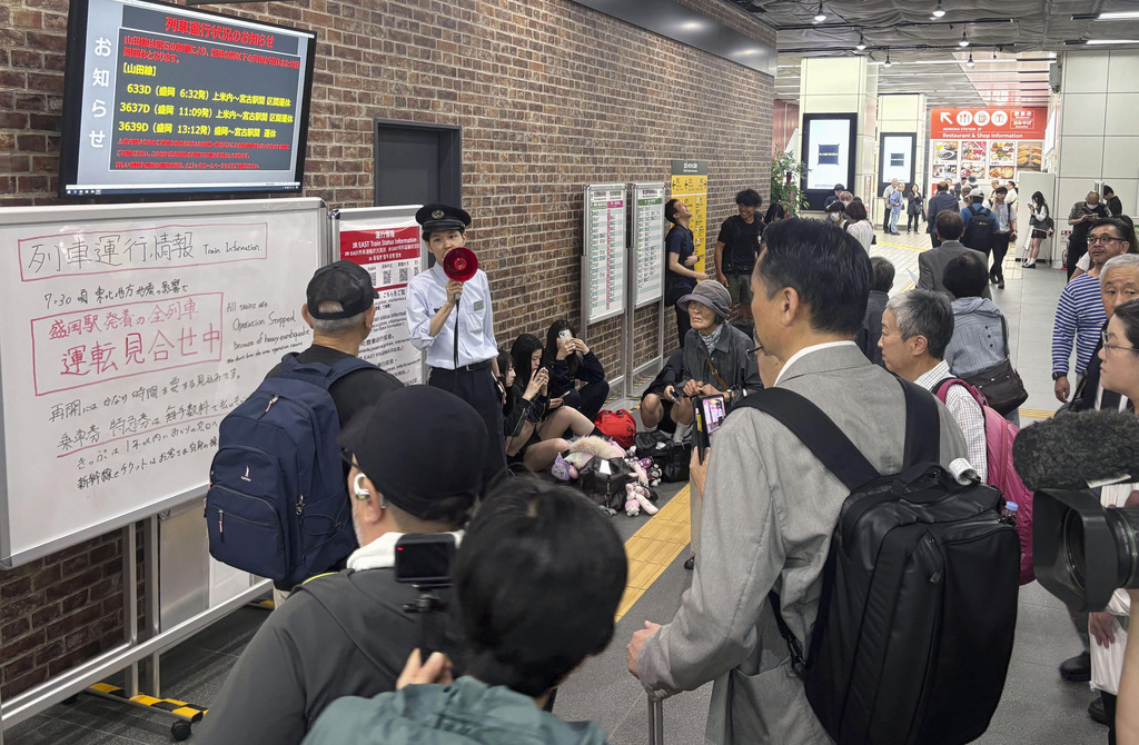 A station clerk of the East Japan Railway Co., provides an update about train services which were suspended due to an earthquake at JR Morioka station in Morioka, northern Japan, Thursday, July 25, 2026. (Kyodo News via AP)