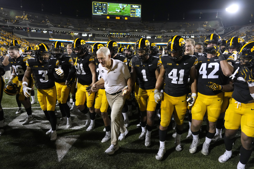 Iowa head coach Kirk Ferentz, center, runs off the field with his team after an NCAA college football game against Massachusetts, Saturday, Sept. 13, 2025, in Iowa City, Iowa. (AP Photo/Charlie Neibergall)