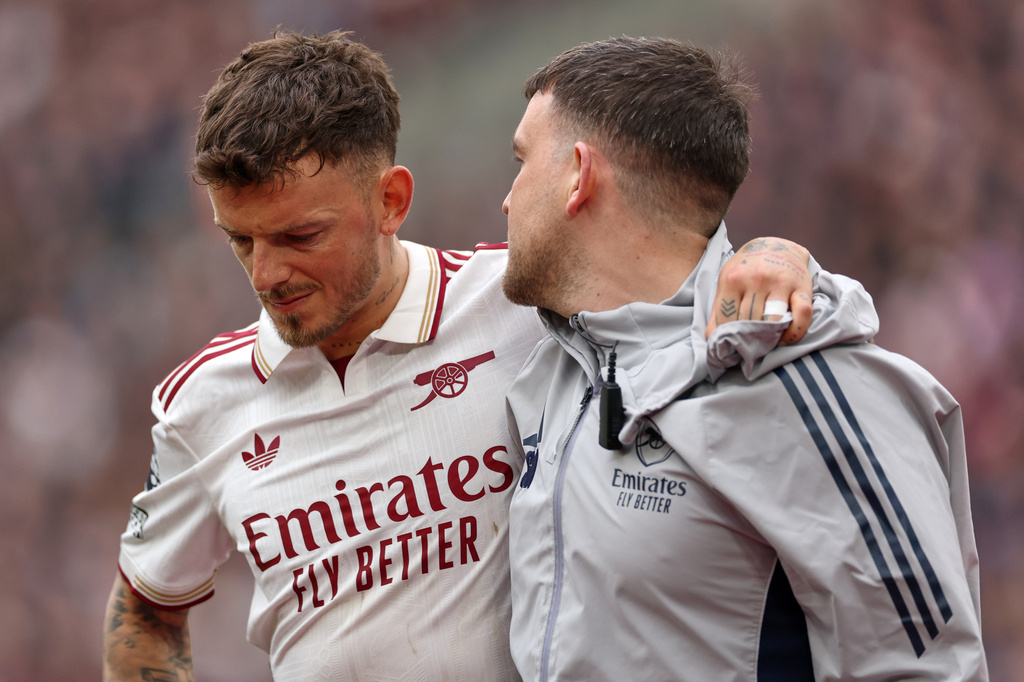 Arsenal's Ben White is helped off the pitch after getting injured during the English Premier League soccer match between West Ham and Arsenal in London, Sunday, May 10, 2026. (AP Photo/Ian Walton)