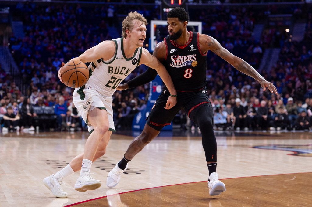 Milwaukee Bucks shooting guard AJ Green, left, drives to the basket against Philadelphia 76ers small forward Paul George, right, during the first half of an NBA basketball game, Sunday, April 12, 2026, in Philadelphia. (AP Photo/Chris Szagola)