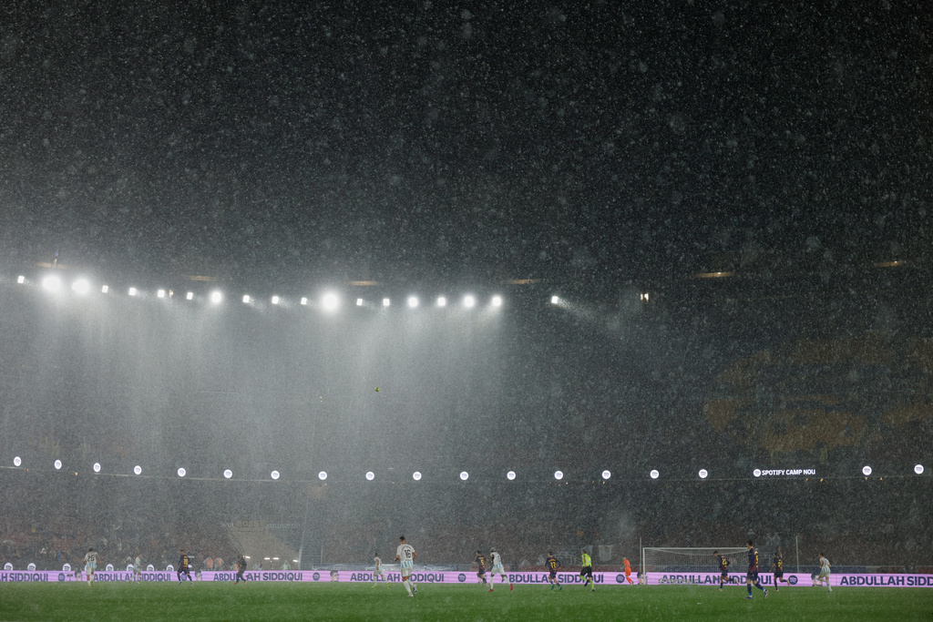 A heavy rain falls on the field during a Spanish La Liga soccer match between Barcelona and Real Oviedo in Barcelona, Spain, Sunday, Jan. 25, 2026. (AP Photo/Joan Monfort)