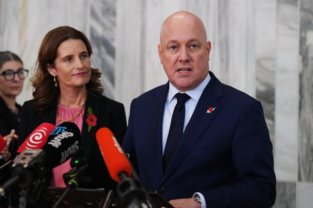 FILE - New Zealand Prime Minister Christopher Luxon, right, speaks to reporters at Parliament in Wellington, New Zealand, on April 21 2026. (AP Photo/Charlotte Graham-McLay, File)