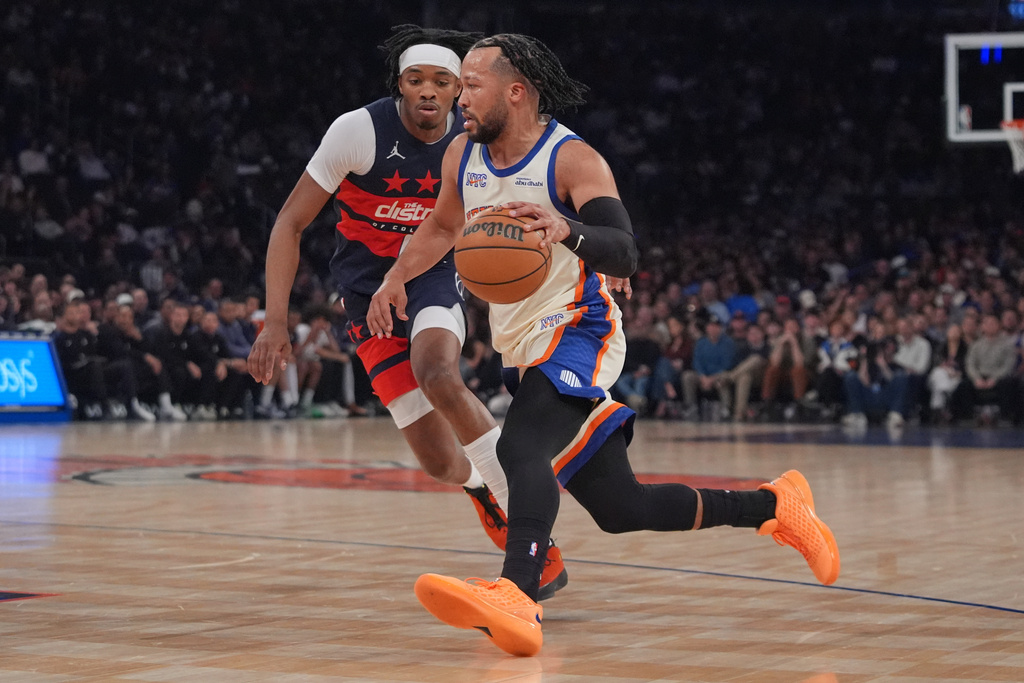 New York Knicks' Jalen Brunson, right, drives past Washington Wizards' Bilal Coulibaly during the first half of an NBA basketball game Sunday, March 22, 2026, in New York. (AP Photo/Frank Franklin II)