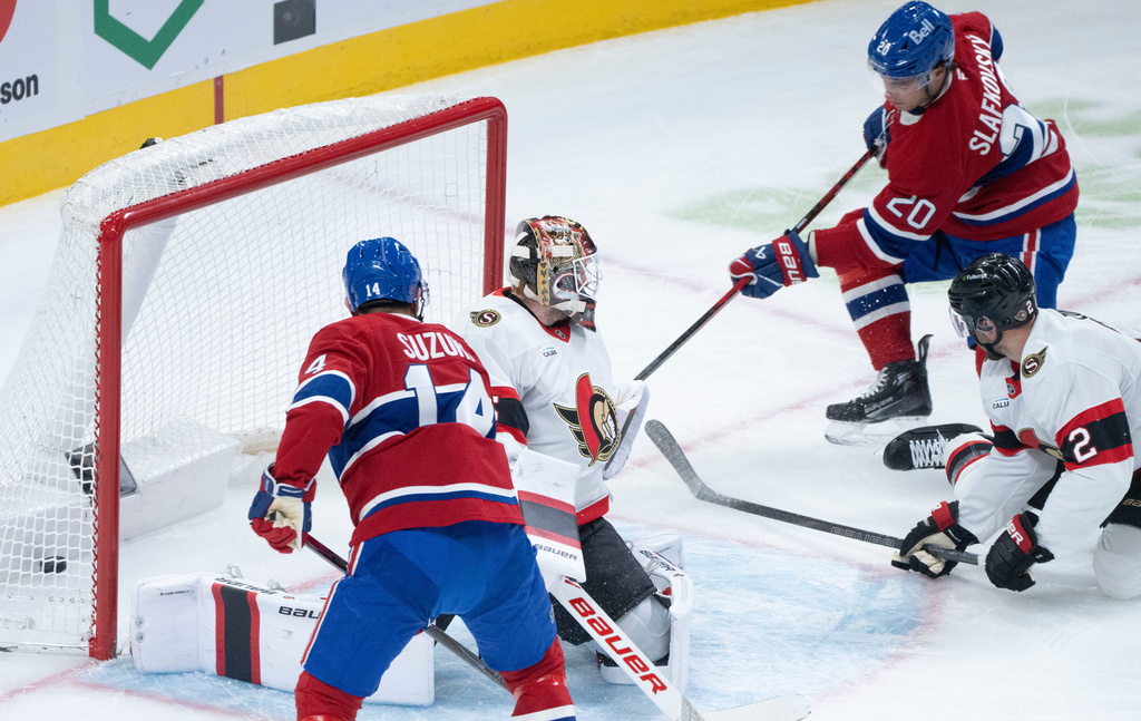 Montreal Canadiens' Juraj Slafkovsky (20) scores on Ottawa Senators goaltender Linus Ullmark (35) as Canadiens' Nick Suzuki (14) looks on during the first period of an NHL hockey game in Montreal, Saturday, Nov. 1, 2025. (Christinne Muschi/The Canadian Press via AP)