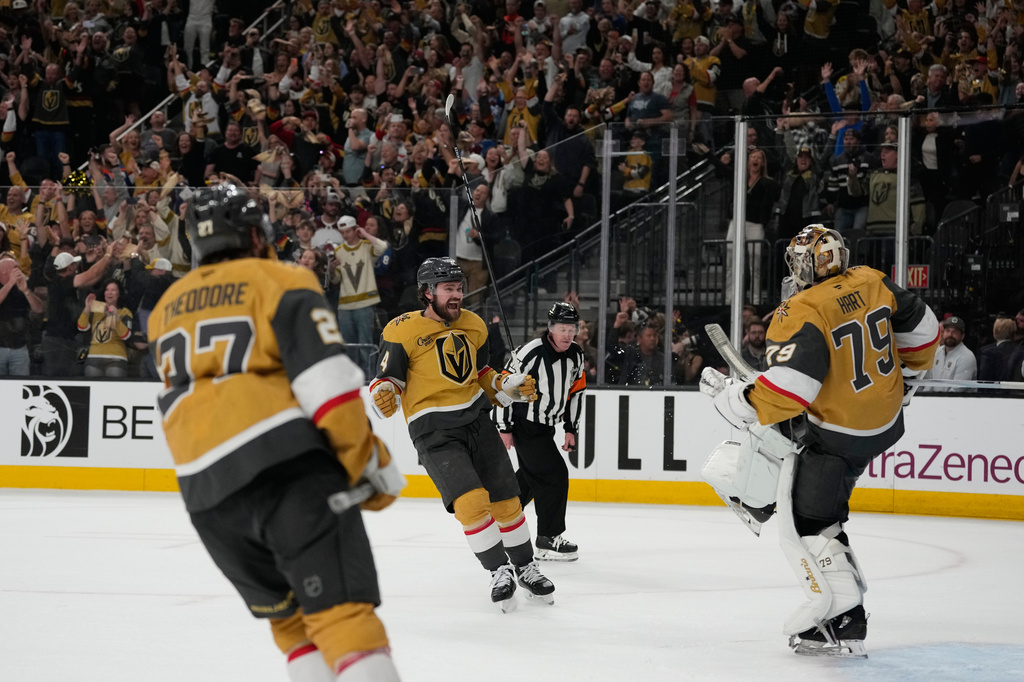 Vegas Golden Knights defenseman Shea Theodore (27), defenseman Rasmus Andersson (4) and goaltender Carter Hart (79) celebrate after winning Game 4 of the Western Conference finals NHL hockey Stanley Cup playoff series against the Colorado Avalanche Tuesday, May 26, 2026, in Las Vegas. (AP Photo/John Locher)