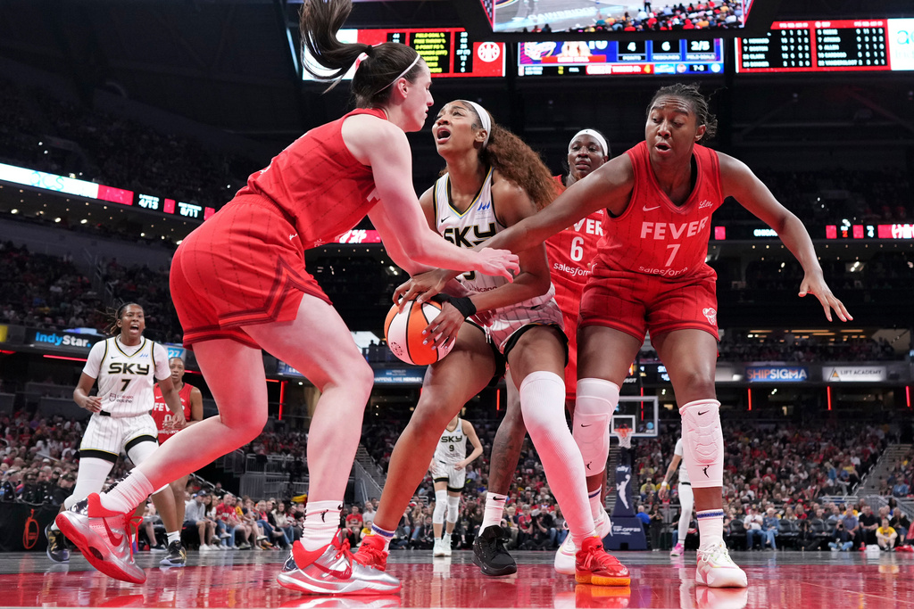 FILE - Indiana Fever guard Caitlin Clark, left, fouls Chicago Sky forward Angel Reese, center, during the second half an WNBA basketball game in Indianapolis, Saturday, May 17, 2025. (AP Photo/AJ Mast, File)