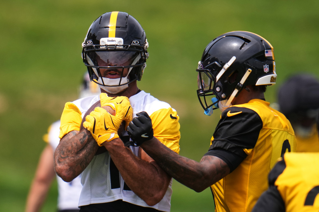 Pittsburgh Steelers safety Jaquan Brisker, right, attempt to punch the ball from the grasp of wide receiver Michael Pittman Jr., during the NFL team's camp in Latrobe, Pa., Saturday, Aug. 1, 2026. (AP Photo/Gene J. Puskar)