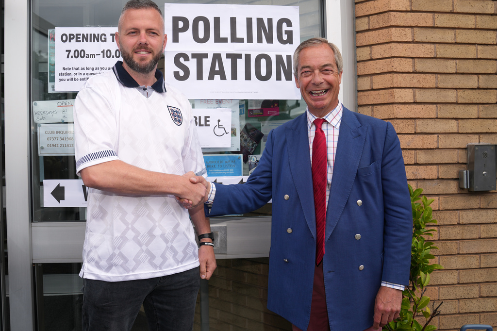 Britain's Reform Party leader Nigel Farage and local candidate Rob Kenyon ashake hands at a polling station during the by-election in Makerfield, England, Thursday, June 18, 2026.(AP Photo/Jon Super)