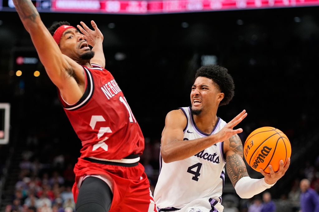 Kansas State guard P.J. Haggerty (4) looks to pass around Nebraska guard Jamarques Lawrence (10) during the first half of an NCAA college basketball game Friday, Nov. 21, 2025, in Kansas City, Mo. (AP Photo/Charlie Riedel)