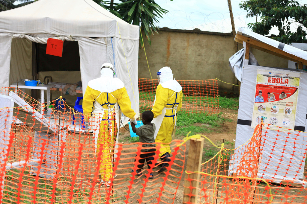 FILE - Health workers walk with a boy suspected of having the Ebola virus at an Ebola treatment center in Beni, eastern Congo, Sept 9, 2018. (AP Photo/Al-hadji Kudra Maliro, File)