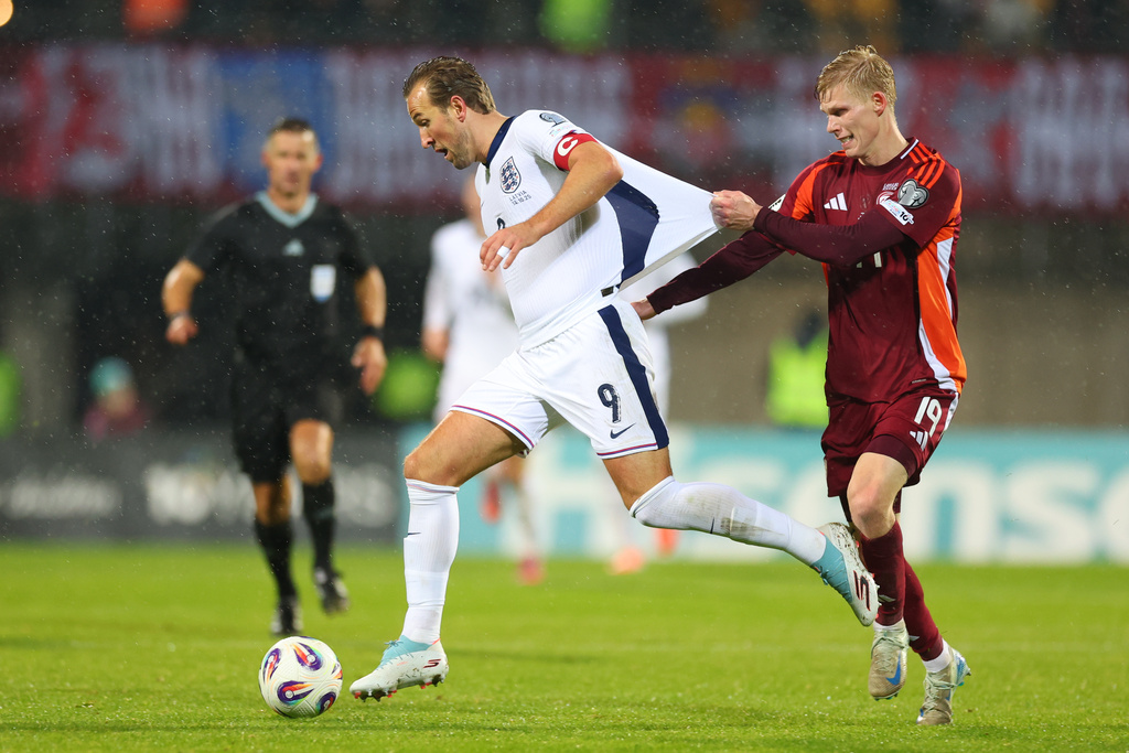 Latvia's Maksims Tonisevs, right, pulls the shirt of England's Harry Kane during the 2026 World Cup group K qualifying soccer match between Latvia and England in Riga, Latvia, Tuesday, Oct. 14, 2025. (AP Photo/Roman Koksarov)