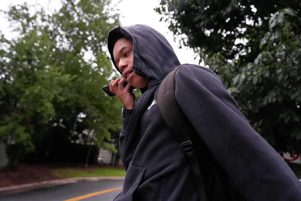 Elias Washington talks to a friend on the phone as he walks to Midtown High School on Aug. 4, 2025, in Atlanta. (AP Photo/Brynn Anderson)