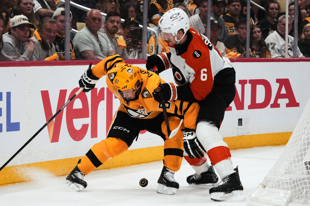 Pittsburgh Penguins' Sidney Crosby (87) is defended by Philadelphia Flyers' Travis Sanheim (6) during the second period of Game 1 in the first round of the NHL Stanley Cup playoffs in Pittsburgh, Saturday, April 18, 2026. (AP Photo/Gene J. Puskar)