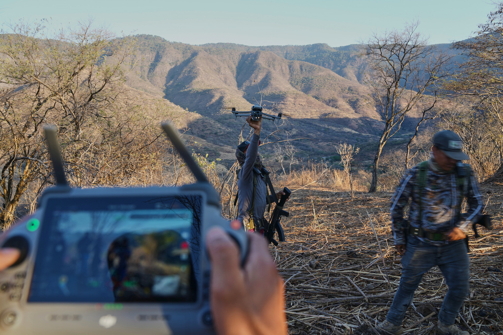 Members of a local self-defense group formed by residents in response to cartel violence fly a drone in Guajes de Ayala, Mexico, Tuesday, March 10, 2026. (AP Photo/Marco Ugarte)