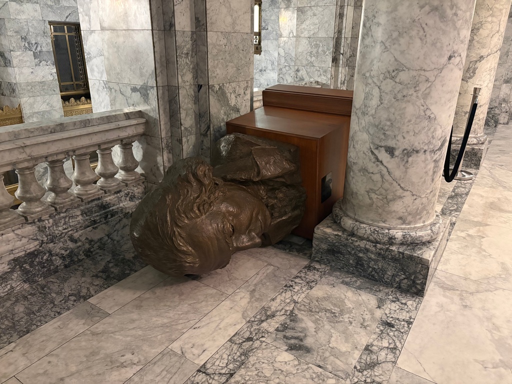 In this undated photo provided by the Department of Enterprise Services, a Washington state government agency, the bust of George Washington sits toppled over inside the capitol in Olympia, Wash., after an intruder broke in and vandalized the Legislative building on the evening of Oct. 5, 2025. (Department of Enterprise Services via AP)