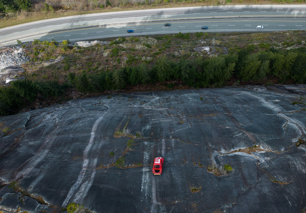 The shell of a Volkswagen Beetle hangs suspended on a cliff above the Sea-to-Sky Highway, in Squamish, British Columbia, Monday, April 6, 2026, after it appeared on the rock face last week with a large "E" on its roof, indicating that University of British Columbia engineering students carried out a long-standing tradition of placing the shell in difficult to reach locations. (Darryl Dyck/The Canadian Press via AP)