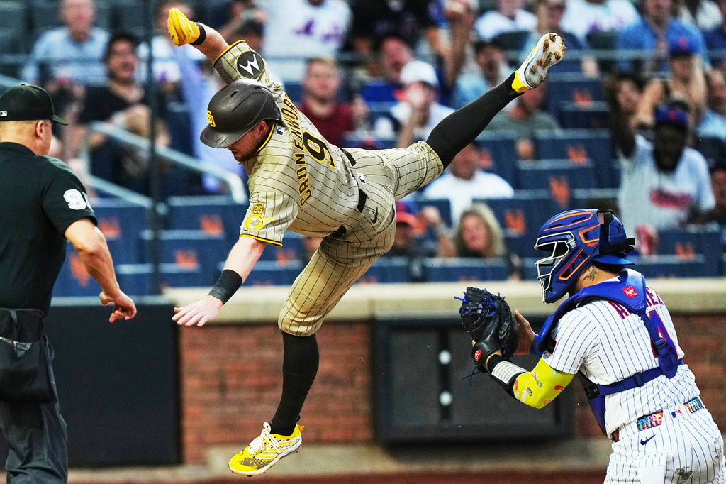 New York Mets' Francisco Alvarez (4) tags out San Diego Padres' Jake Cronenworth (9) at home plate during the first inning of a baseball game Monday, Aug. 17, 2026, in New York. (AP Photo/Frank Franklin II)
