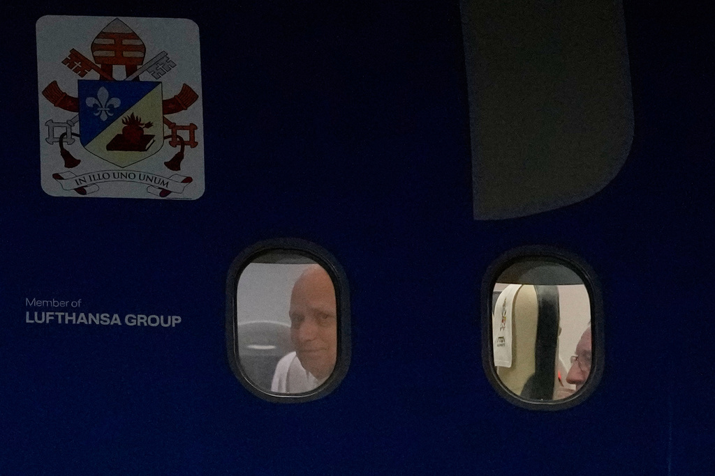 Pope Leo XIV peers from a window on board his papal plane bound to Istanbul, at Esenboga International Airport in Ankara, Turkey, Thursday, Nov. 27, 2025, during the first of his six-day trip to Turkey and Lebanon. (AP Photo/Khalil Hamra)