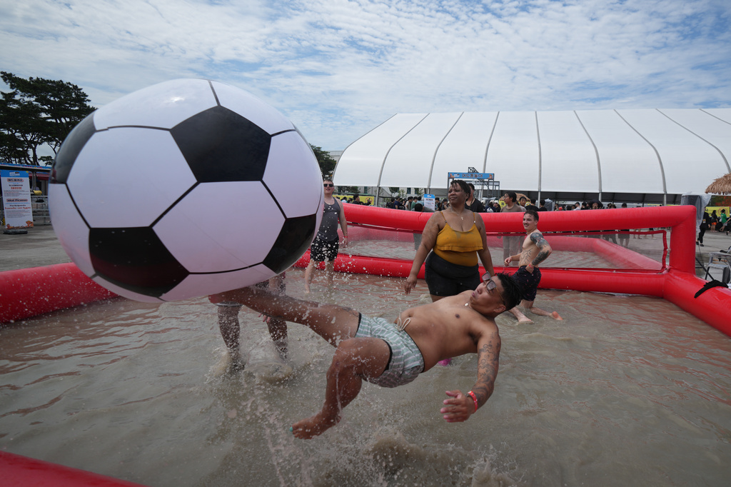 Chito Baro of the U.S. plays with a ball during the Boryeong Mud Festival near a beach in Boryeong, South Korea, Saturday, July 25, 2026. (AP Photo/Lee Jin-man)