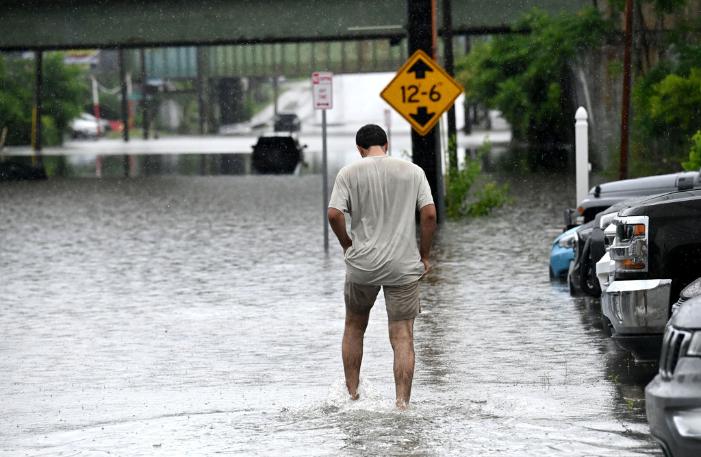 A person wades through floodwater on Central Avenue near Interstate 90 after heavy rainstorms caused damage throughout the Capital Region on Wednesday, July 29, 2026, in Albany, N.Y. (Will Waldron/The Albany Times Union via AP)
