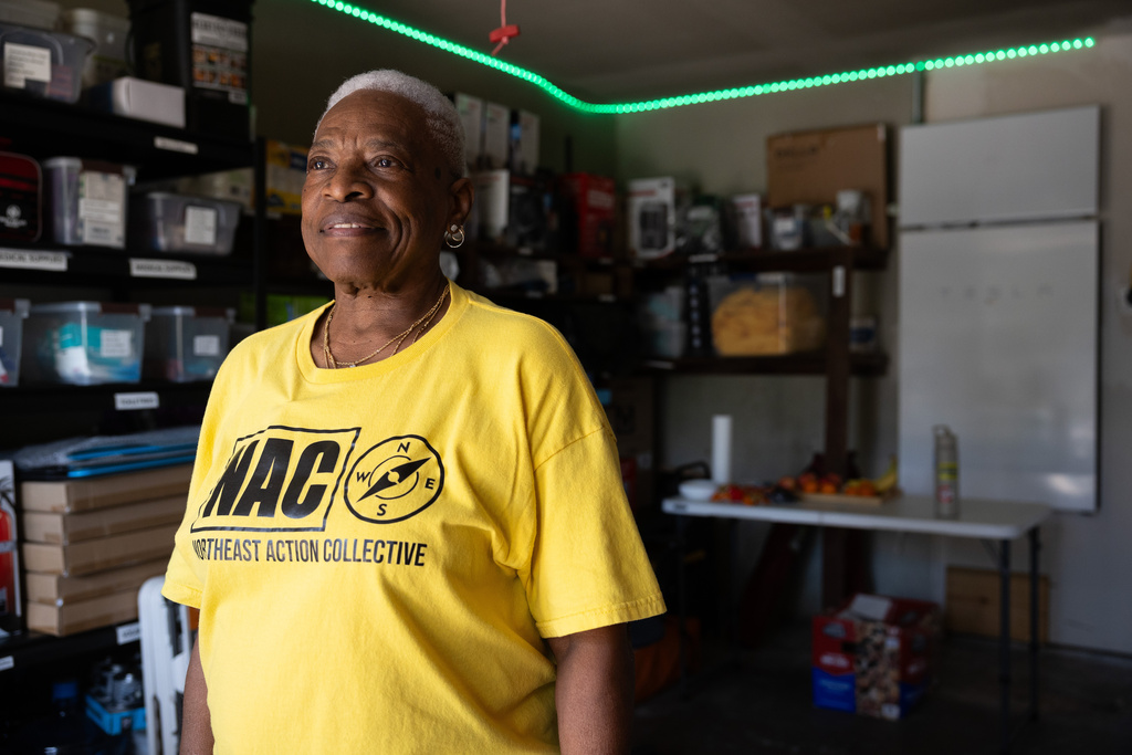 Doris Brown, Hub home captain, poses for a portrait in her garage next to a Tesla Powerwall battery that is charged by the solar panels on top of her home, Wednesday, Oct. 8, 2025, in Houston. (AP Photo/Antranik Tavitian)