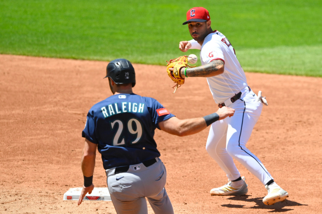 Cleveland Guardians shortstop Brayan Rocchio, right, bobbles the ball after forcing out Seattle Mariners' Cal Raleigh (29) during the third inning of a baseball game, Sunday, June 28, 2026, in Cleveland. (AP Photo/David Richard)