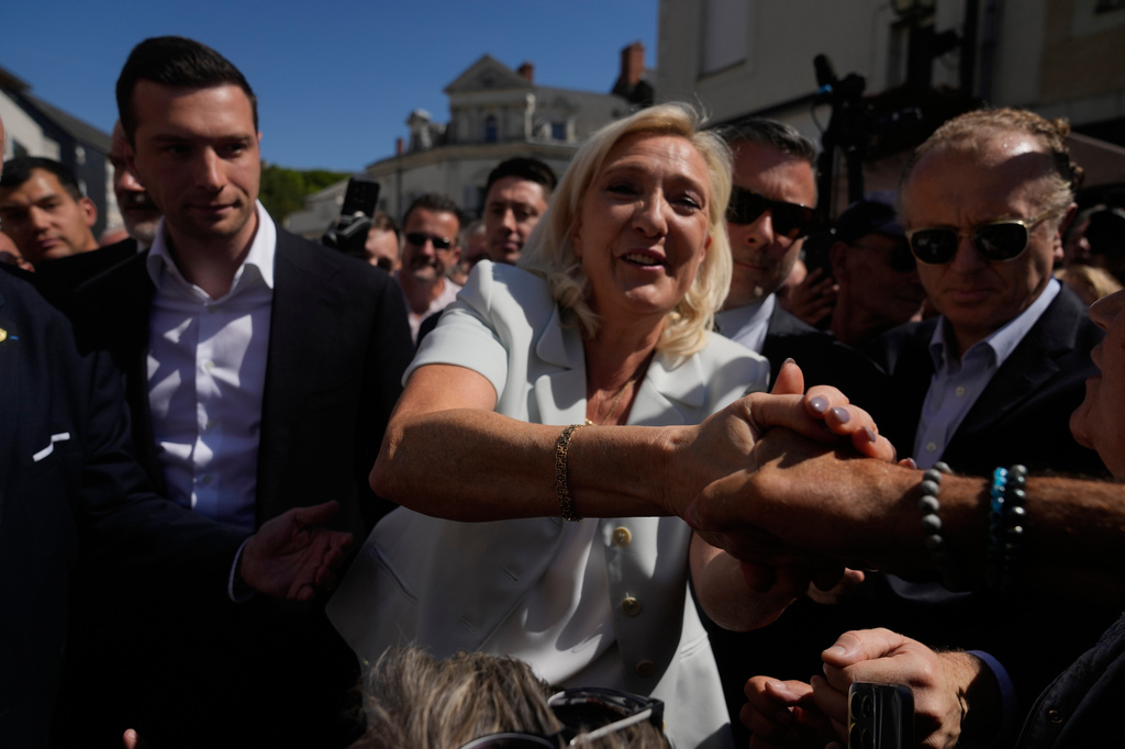 Far-right leader Marine Le Pen and far-right party National Rally president Jordan Bardella arrive to visit a market in La Fleche, western France Wednesday, July. 8, 2026. (AP Photo/Michel Euler)