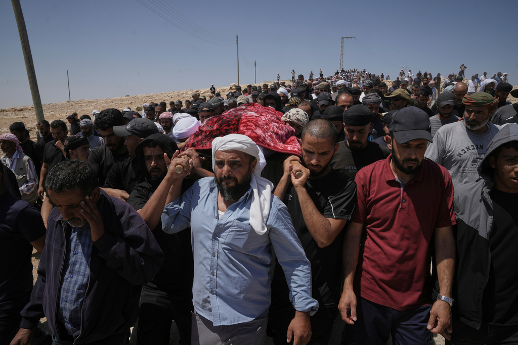 FILE - Mourners carry the body of Palestinian activist Awdah Hathaleen during his funeral in the West Bank Bedouin village of Umm al-Khair, Aug. 7, 2025. (AP Photo/Mahmoud Illean, file)