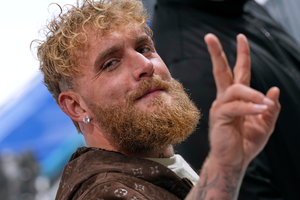 Jake Paul of the U.S. flashes a V-sign as he arrives to support his fiancé Jutta Leerdam of the Netherlands competing in the women's 1,000 meters speedskating race at the 2026 Winter Olympics, in Milan, Italy, Monday, Feb. 9, 2026. (AP Photo/Luca Bruno)
