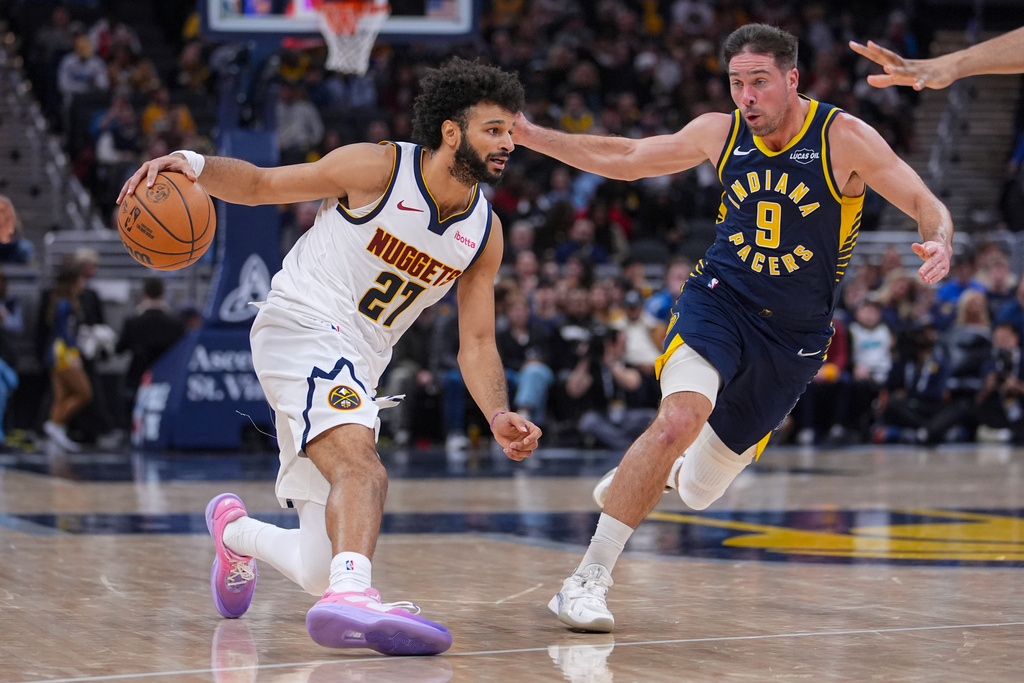 Denver Nuggets guard Jamal Murray (27) drives on Indiana Pacers guard T.J. McConnell (9) during the second half of an NBA basketball game in Indianapolis, Wednesday, Dec. 3, 2025. (AP Photo/Michael Conroy)