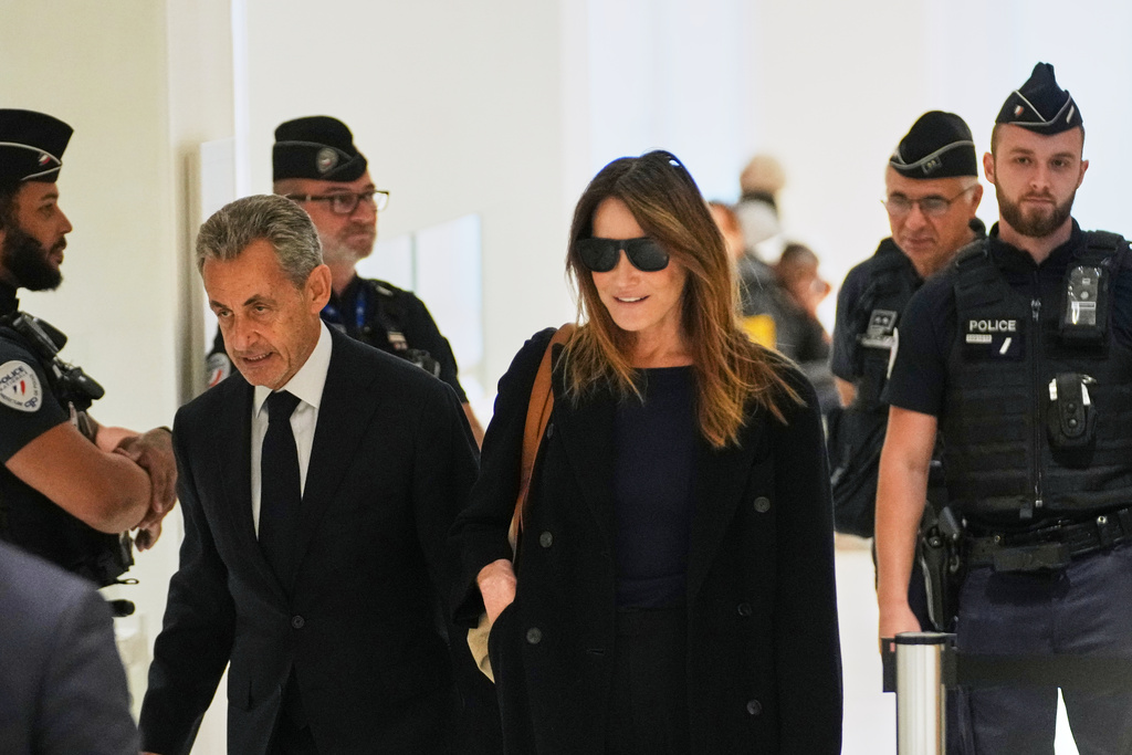 Former French President Nicolas Sarkozy, left, and his wife Carla Bruni, right, arrive at the courthouse, in Paris, France, Thursday, Sept. 25, 2025. (AP Photo/Christophe Ena)