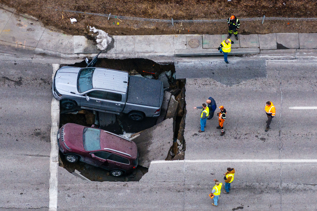 FILE - Authorities assess two vehicles that fell into a sinkhole in Omaha on Feb. 24, 2026. (Chris Machian/Omaha World-Herald via AP, File)