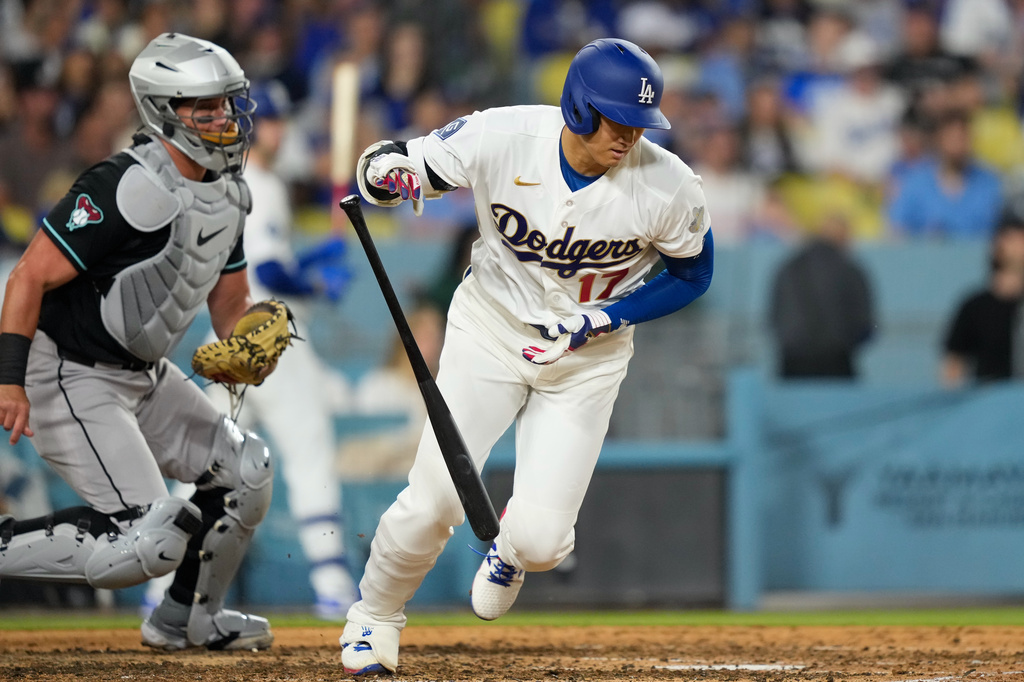 Los Angeles Dodgers' Shohei Ohtani, right, drops his bat as he hits into a double play as Arizona Diamondbacks catcher James McCann watches during the fifth inning of a baseball game Saturday, March 28, 2026, in Los Angeles. (AP Photo/Mark J. Terrill)